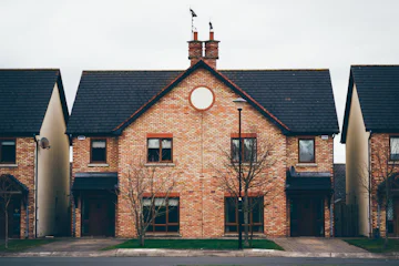 Grande maison en brique au toit d'ardoise avec cheminées
